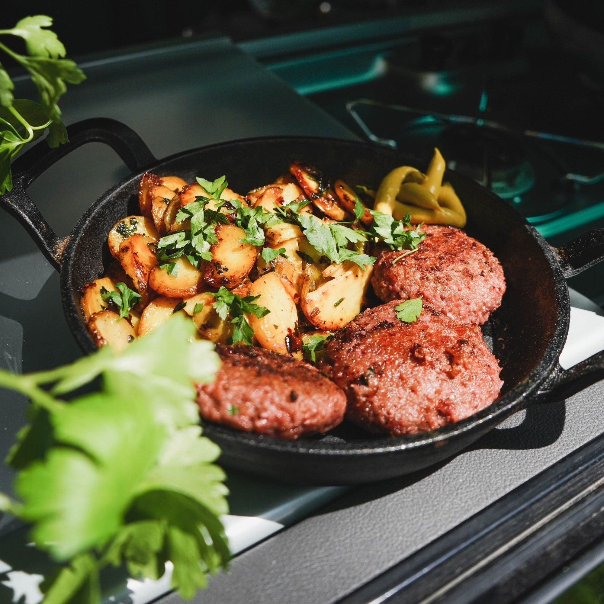 Camping-Frikadellen in einer Pfanne mit Bratkartoffeln