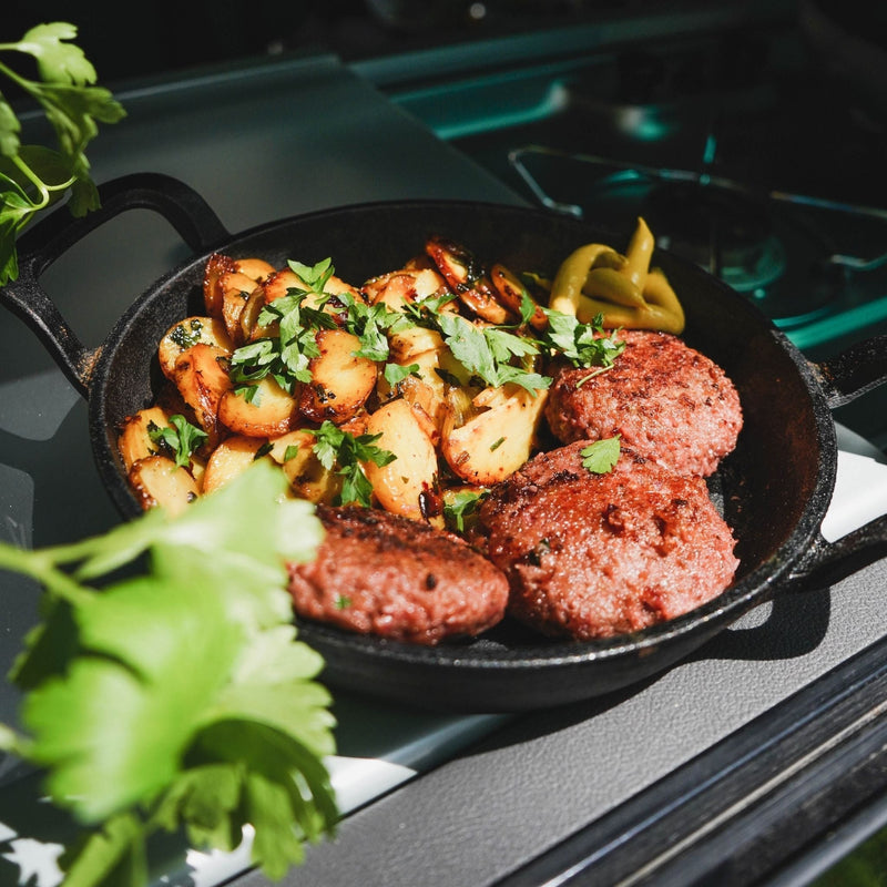 Camping-Frikadellen in einer Pfanne mit Bratkartoffeln