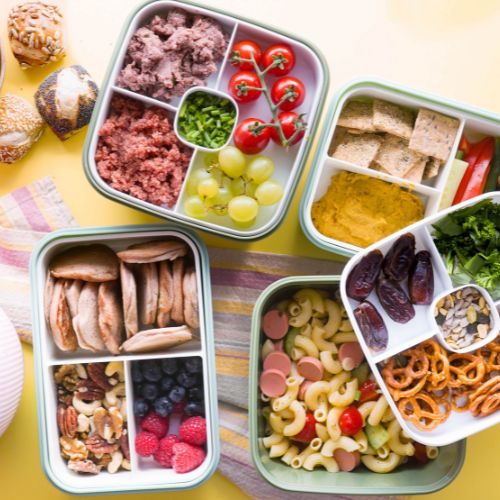 Verschiedene gefüllte Lunchboxes mit GREENFORCE Produkten nebeneinander auf einem Tisch