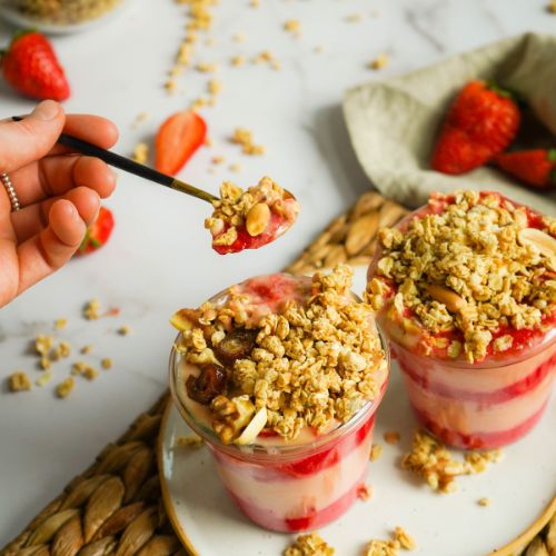 Leckerer Erdbeer-Vegurt im Glas mit Granola und frischen Erdbeeren
