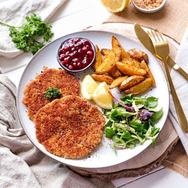 Knuspriges veganes Schnitzel mit Kartoffel-Wedges und Preiselbeersauce 